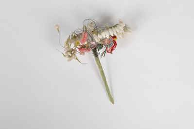 052a3fd7-ec17-4d22-9899-6cf7b4940401.jpg; 2013-0019-ODI; Corsage van rode, witte en gele papieren bloemen, een kleine roodroze rozet en een beschilderd blad van zijde; corsage