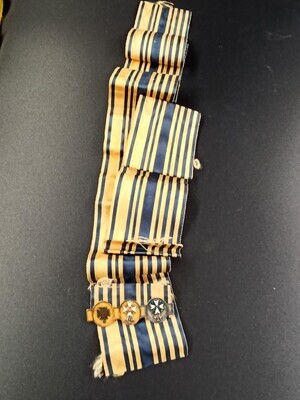 05440f0b-e550-4552-850c-cb9a9be90fb6.jpg; 0000-0351-HHI/o; Speld met 3 gedenkkruizen op blauw/geel lint.; insignes (broches)