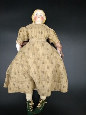 05fd8ed6-a34f-4d3f-8600-cdebbf9d9cc1.jpg; 1960-0183-KPO/1-8; Aangeklede pop met stenen hoofdje en armen. Een zeemleren lijfje en blond kapsel met zwarte haarband. Draagt gekleurde jurk.; poppen