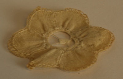 1960-0282-KPO-16-51.jpg; 1960-0282-KPO/16-51; Rozetje van Brussels kant uit de salon van het grote poppenhuis.; kleedjes