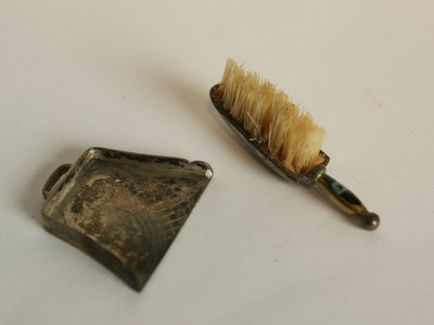 1960-0282-KPO-21-07.jpg; 1960-0282-KPO/21-07/b; Zilveren blik, deel uitmakend van een stoffer-en-blik.; miniaturen