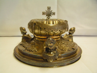 2006x0026-OME.jpg; 2006x0026-OME; Verguld zilverenen ciboriedeksel met afgebeeld gevleugelde cherubkopjes en korenhalmen met druiventrossen.; deksels