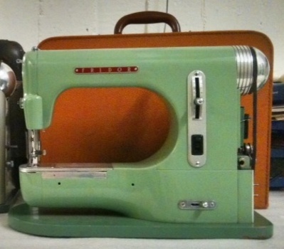 2012-0003-HHI.jpg; 2012-0003-HHI/b; Oranjebruine kunststof beklede koffer voor een groene Fridor naaimachine.; koffer