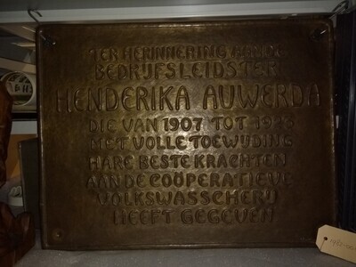 29f6f393-3993-4879-8ef0-db5d31e99c43.jpg; 1982-0010-HHI; Rechthoekige bronzen plaquette met opschrift: (in relief) TER HERINNERING AAN DE/BEDRIJFSLEIDSTER/HENDRIKA AUWERDA/DIE VAN 1907 tot 1923/ met: enz.; plaquettes (metalen reliëfs)