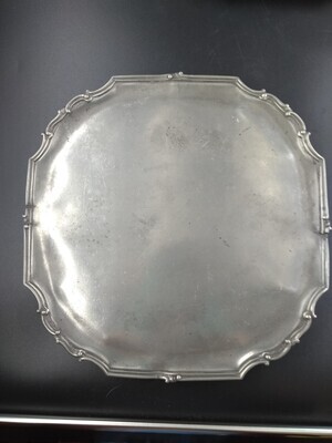 57eb58d4-70c5-4e0f-862f-bbbd8233aaed.jpg; 1979x0012-OMO/b; Vierkant dienblad, met randje van rechte en gebogen profielen, 4 platte gegolfde pootjes. Gemerkt: 4 merk van Jan ten Winkel.; huishoudelijke artikelen