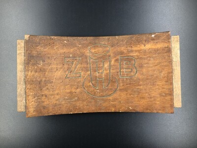 89209afc-335e-4542-97d7-9a290c3f1fd2.jpg; 1993-0034-HHI; Rugleuning van een stoel met ingegraveerd ZHB-logo.; stoelen
