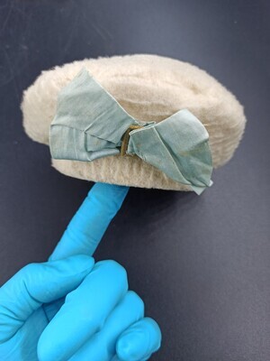 8e7d8430-2b9b-4e23-a9b8-54176e376a1c.jpg; 1960-0118-KPO; Stoffen hoedje met grote strik; poppenkleding