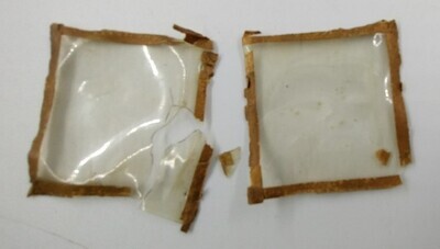 9897139f-4c39-48a3-a47d-fe6204c2e52a.jpg; 1960-0282-KPO/17-24/b; Restanten van de mica beglazing van 2 van de 3 lijstjes met papieren knipsels uit het trapgat in de overloop van het grote poppenhuis.; lijst