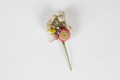 9b6c9697-d115-450c-9dba-d95b92f8cab7.jpg; 2013-0018-ODI; Corsage van rode, witte en gele papieren bloemen, een grote en een kleine roodroze rozet; corsage