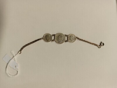 c38a9154-e33a-4c8c-9518-bab3b27f7b56.jpg; 2017-0006-MMO; Een zilverkleurig armbandje met daarin verwerkt drie munten met het portret van Wilhelmina Koningin der Nederlanden; armbanden (onderarm)