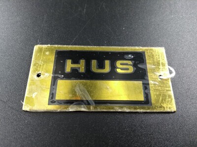 cbeeb0a6-eee5-41cf-a708-e850e3584f98.jpg; 0000-0001-MMO; Metalen koperkleurig naamplaatje van Bakkerij Hus.; naamplaten