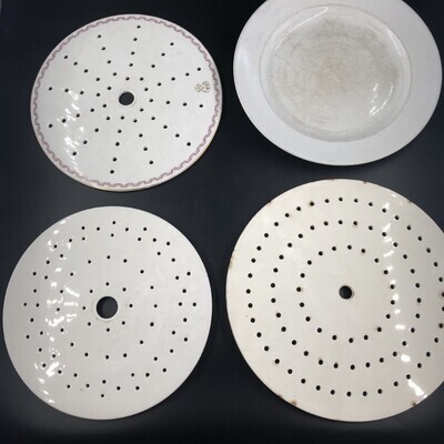 d28d8b91-566c-4103-b0a1-a5b2efea3772.jpg; 1979x0002-OCE/a-c; Een ronde schaal met iets schuine, platte rand. Drie ronde platte treeften doorgeslagen met een gat in het midden en daaromheen cirkels van gaatjes.; eet- en drinkgerei