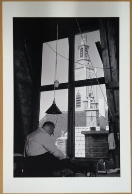 e1d36ae8-8669-49cd-8b63-4961e2b3b0ec.jpg; 2010-0362-PRE; Man aan het werk in een dakkapel met uitzicht op de toren van de Grote Kerk te Den Haag.; fotografie