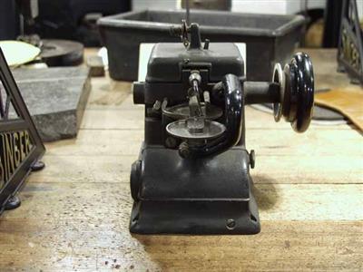 88993.jpg; 88993; Gietijzeren machine met horizontale naald en twee grote transport schijven.; sectionaal tafel